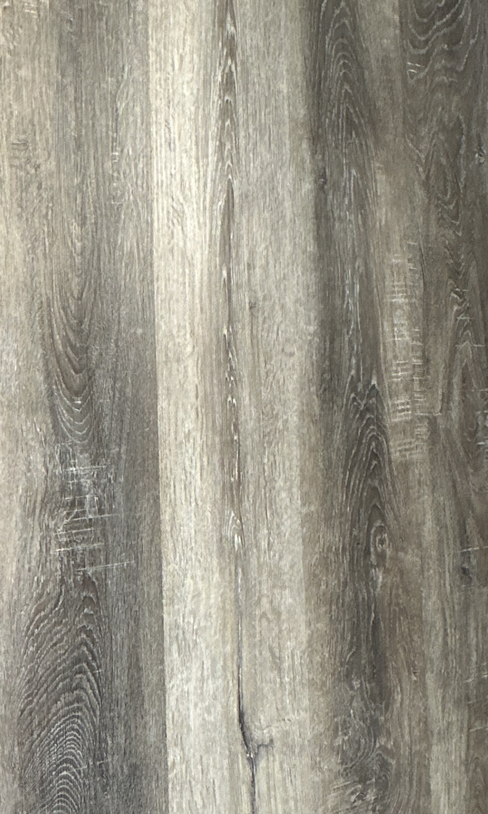 Close-up of Maxwell 6 Paisley glue-down luxury vinyl planks, a weathered gray oak with gray and taupe grain.